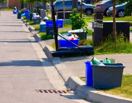 Workers using trolleys and PPE to move bulky waste safely